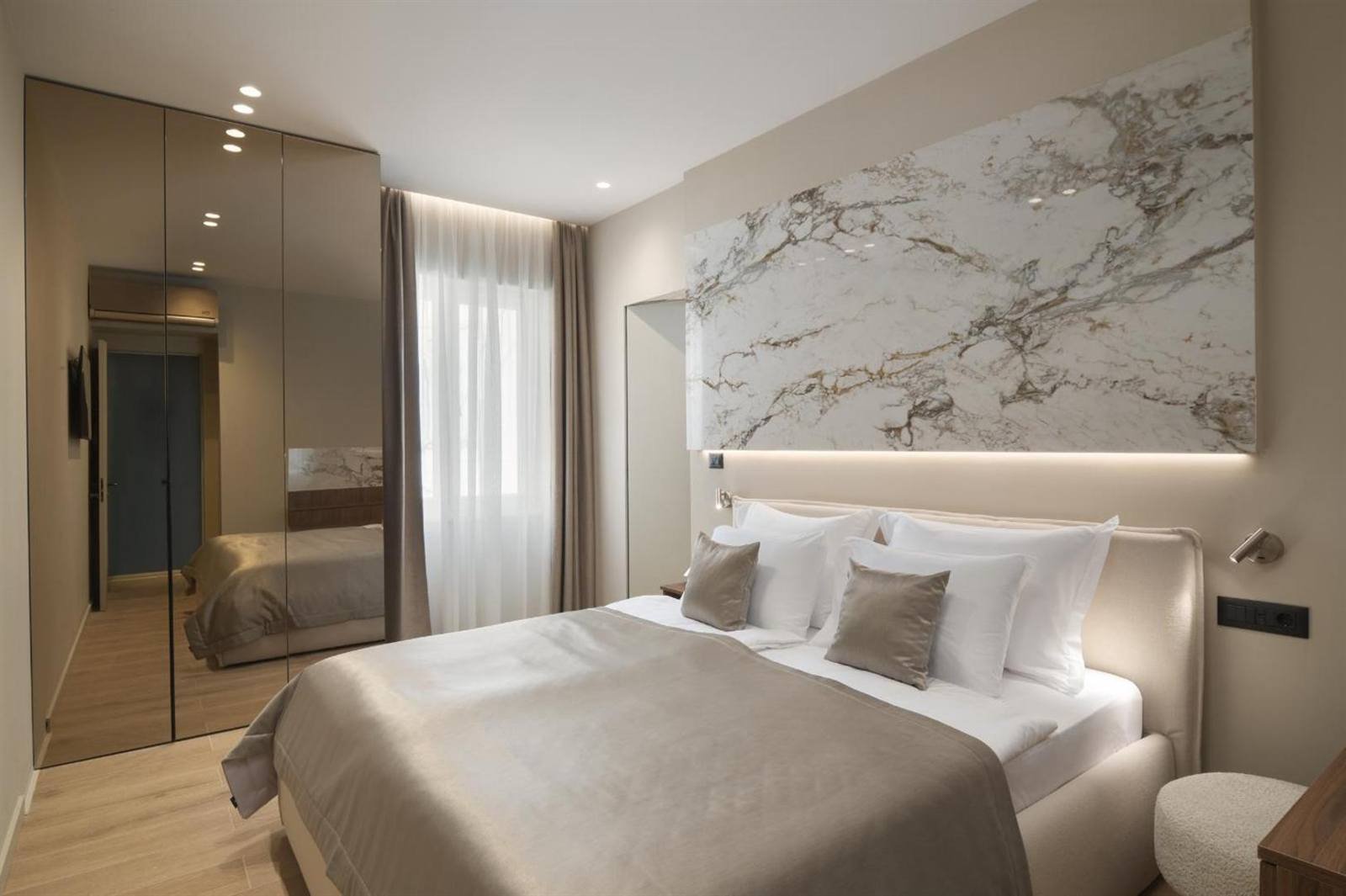Bedroom with a marble-look headboard and soft lighting